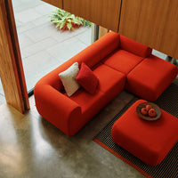 Vibrant red sectional sofa with matching cushions and a geometric black and white striped rug.
