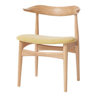 Light wood chair with a curved back and a soft yellow patterned seat.