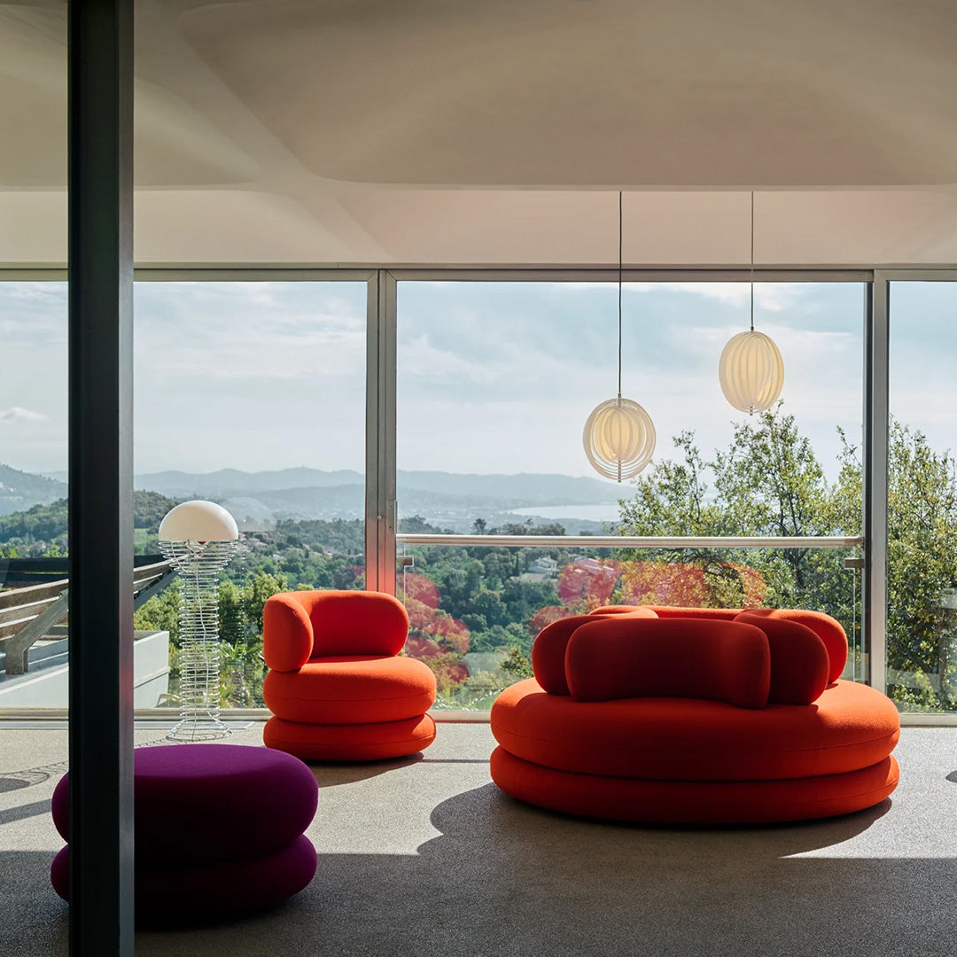 Vibrant orange and purple seating surrounded by natural light and scenic views, enhancing contemporary decor.