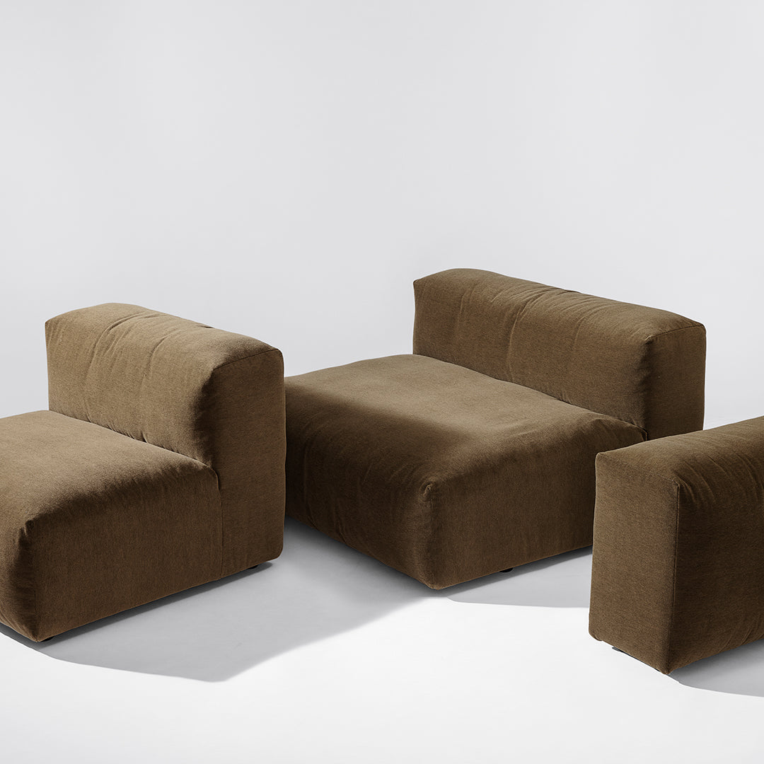 Brown modular sofa set with a smooth, contemporary design and plush texture against a minimalist background.