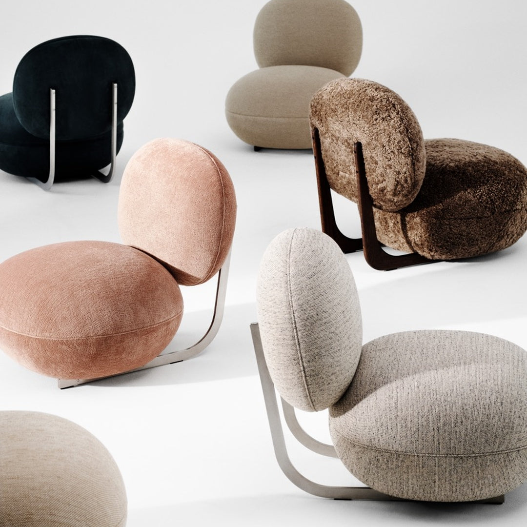 Textured chairs in pastel pink, soft beige, dark green, and rich brown, featuring unique rounded shapes and modern designs.