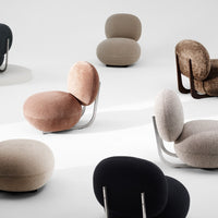 Colorful modern chairs in hues of pink, beige, black, and brown with soft textures and rounded shapes.