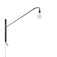 Black metal wall lamp with a white globe bulb and sleek, minimalist design. Simple lines and modern aesthetic.