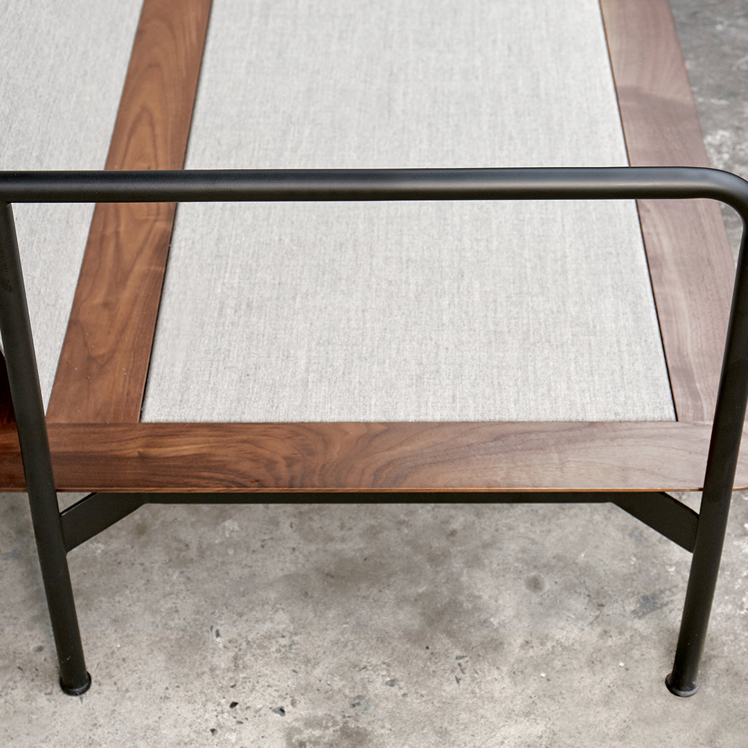 Wooden table with a sleek natural finish, featuring a light gray linen inset and sturdy black metal legs.