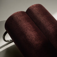 Rich burgundy velvet fabric rolls with a soft sheen and subtle texture, enhancing elegance in any setting.