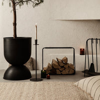 Black planters and candle holders paired with earthy tones and natural textures create a modern, minimalist aesthetic.