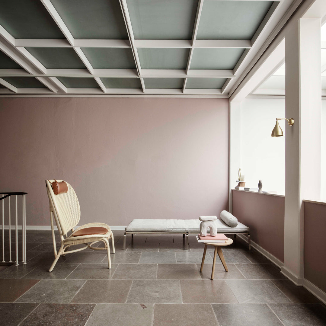 Light pink walls paired with a gray ceiling and slate flooring, featuring minimalist decor.