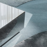 Modern gray and blue area rug with abstract patterns, featuring soft textures and reflective surfaces.