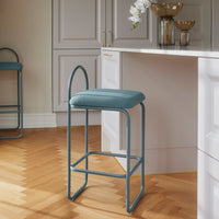 Light blue upholstered bar stool with a sleek metal frame against a warm wood floor and neutral backdrop.