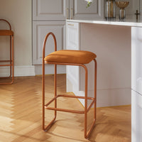 Rust-orange velvet bar stool with sleek copper frame, perfect for modern kitchens or dining areas.