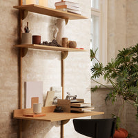 Light wood shelves against a textured beige wall, featuring neutral tones and natural materials with greenery accents.