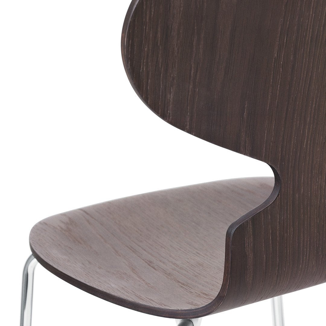 Dark wood grain chair with a sleek, curved back and smooth, seamless design. Modern minimalistic style.