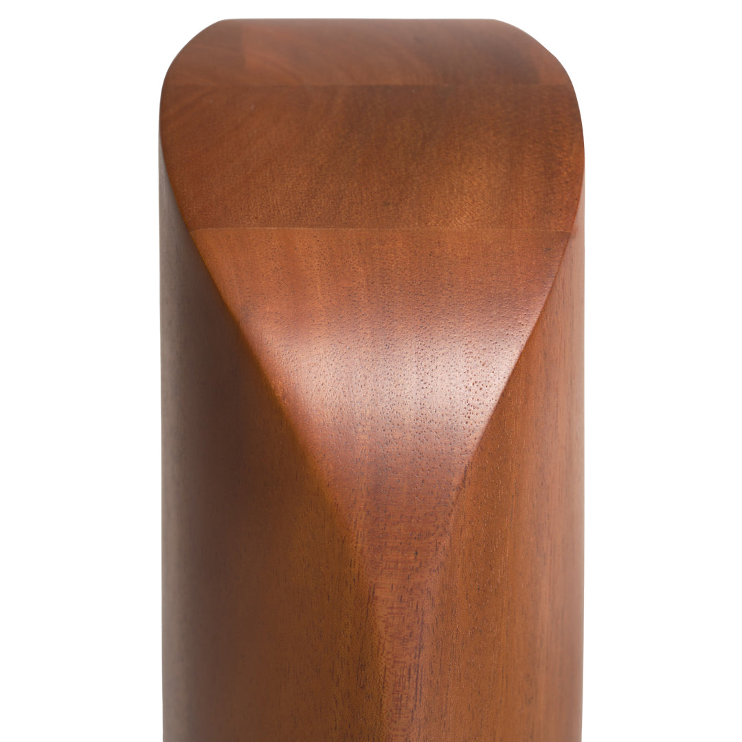 Polished mahogany wood with a smooth, curved edge and warm brown tones, showcasing natural grain patterns.