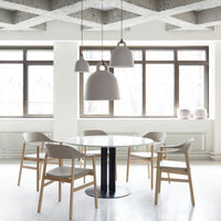 Modern dining set featuring a white table, light wooden chairs, and gray pendant lights against a bright, minimalist space.
