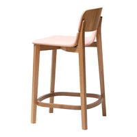 Light pink seat with natural wood legs, minimalistic design ideal for modern decor.