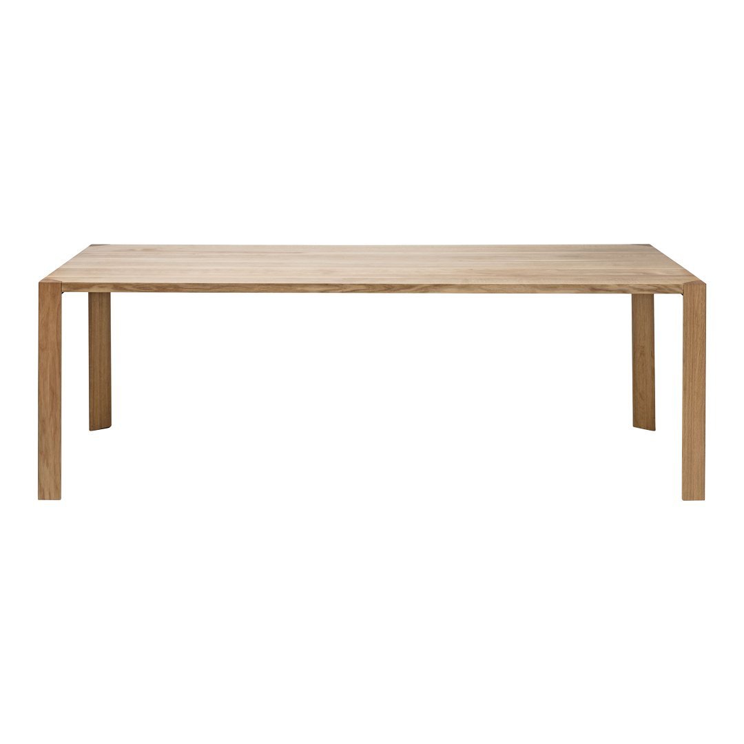 Natural wood dining table with a smooth, light oak finish and minimalist design, featuring clean lines and no patterns.