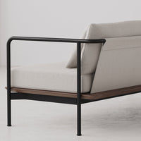 Light beige sofa with a sleek black metal frame and natural wood accent on a minimalist background.