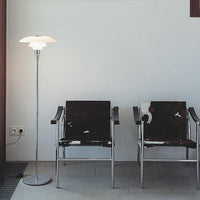 Modern interior featuring sleek chrome chairs with black and white cowhide patterns, illuminated by a stylish lamp.