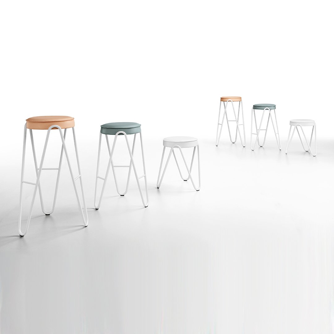 Colorful modern bar stools in shades of orange, teal, white, and light gray with minimalistic white legs.