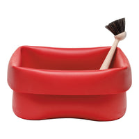 Red rectangular storage container with smooth finish, paired with a brush featuring a wooden handle and dark bristles.