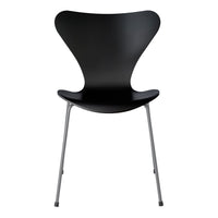 Black molded chair with a sleek, modern silhouette and silver metal legs, showcasing minimalist design.