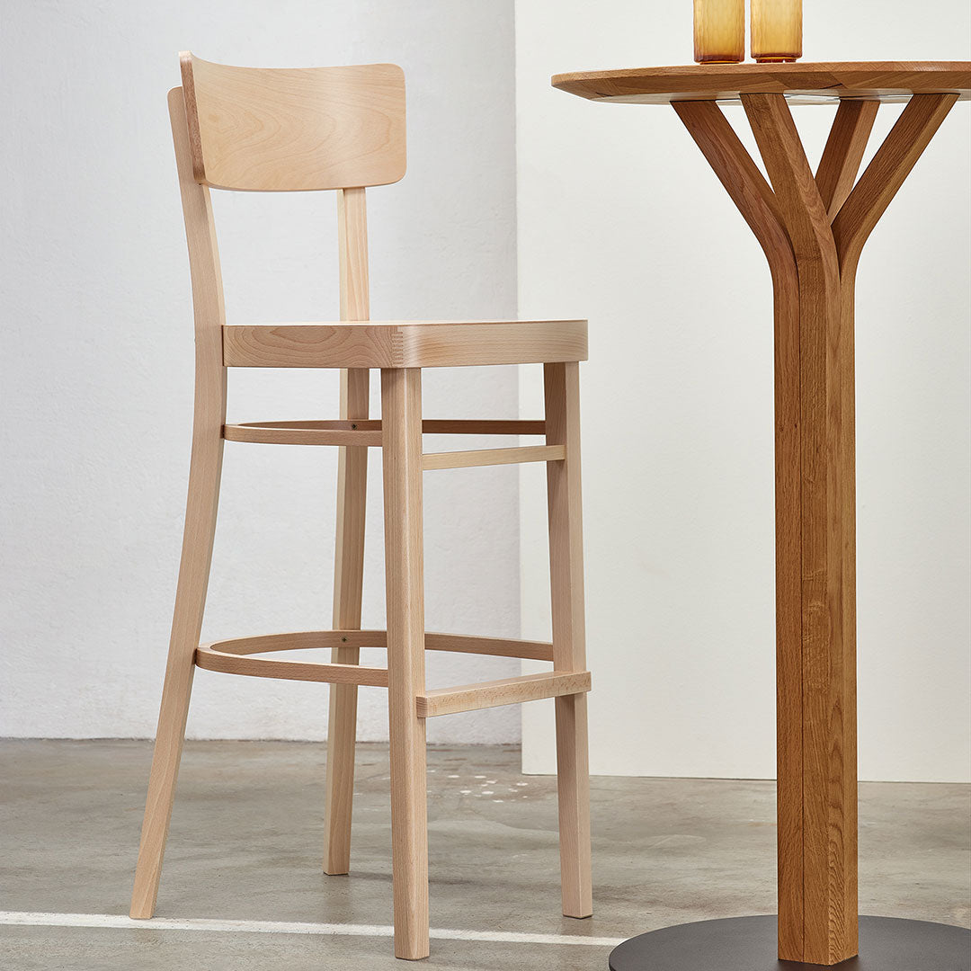 Light natural wood bar stool with a smooth, minimalist design, complementing a modern wooden table.