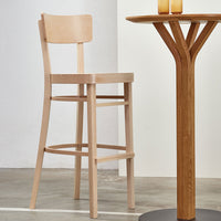 Light natural wood bar stool with a smooth, minimalist design, complementing a modern wooden table.