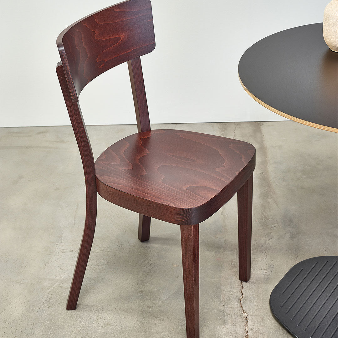 Dark mahogany chair with smooth, curved lines and a glossy finish. Minimalist design complements modern decor.
