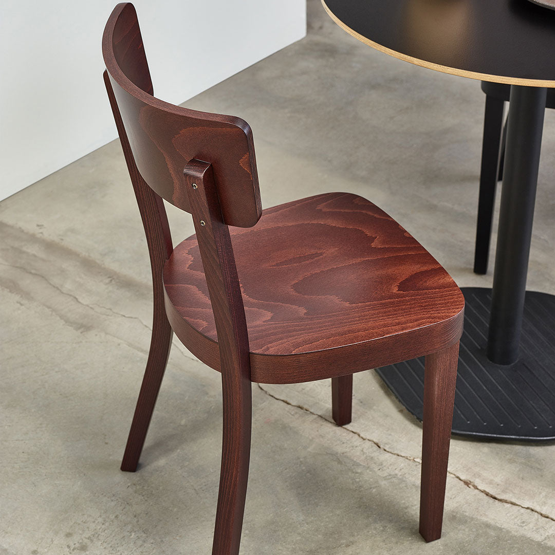 Mahogany wooden chair with smooth surface and curved backrest, showcasing rich, dark tones and natural wood grain patterns.