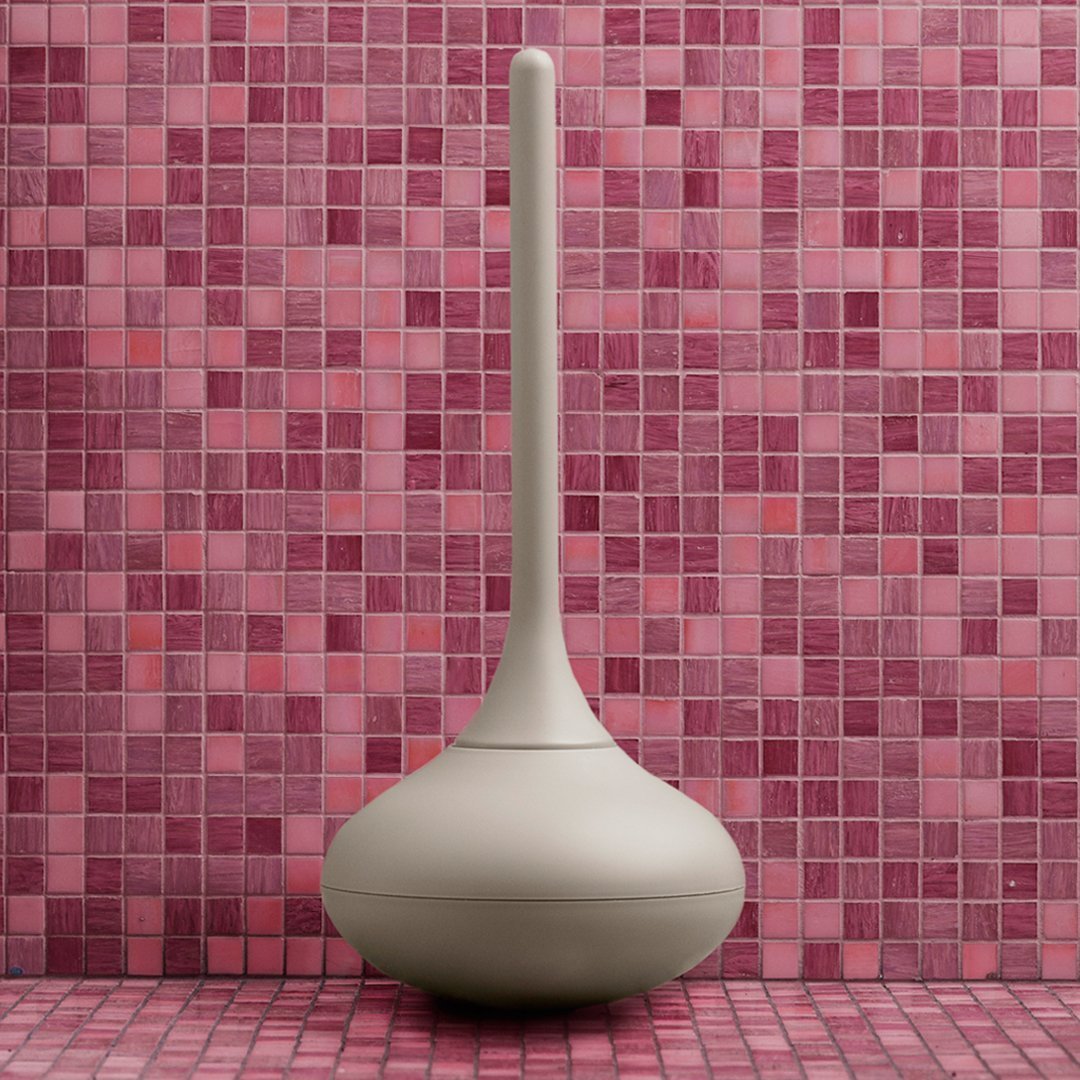 Beige modern vase against a vibrant pink mosaic tiled background, featuring varied shades and patterns.