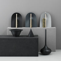 "Elegant black and gray vases with unique shapes and textures, set against a minimalist backdrop."