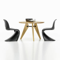 Modern black chairs with smooth curves paired with a round wooden table featuring a natural finish. Clean, minimalist design.