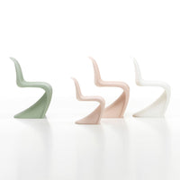 Set of three modern chairs in soft pastel colors: mint green, blush pink, and crisp white with sleek, curved designs.
