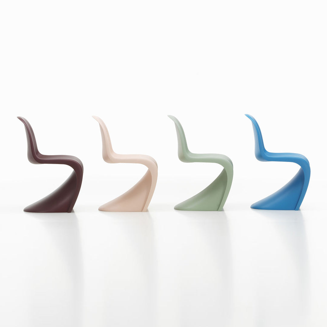 Set of four modern chairs in rich brown, soft pink, muted green, and vibrant blue with sleek, curved designs.