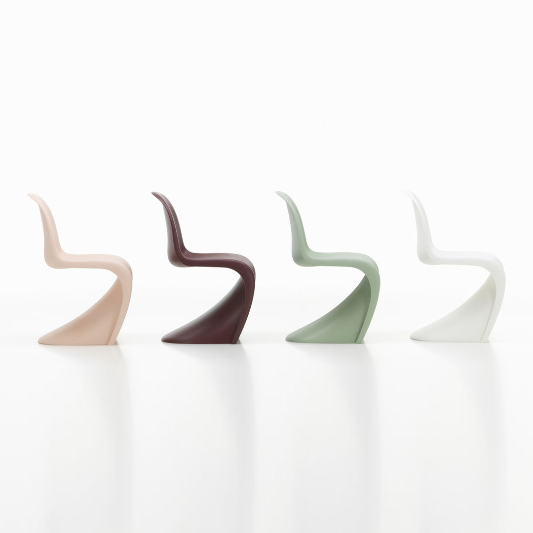 Four stylish chairs in blush pink, deep burgundy, muted green, and crisp white, showcasing sleek, modern designs.
