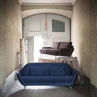 "Elegant navy blue sofa with button-tufted design, complementing a modern brown couch in a chic, minimalist setting."