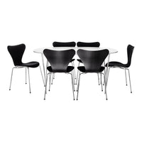 Black chairs with sleek curves surround a modern white tabletop, showcasing a minimalist design.