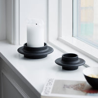 Black ceramic candle holders with a minimalist design, featuring smooth surfaces and circular patterns. Elegant and modern.