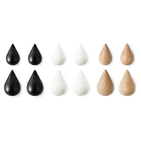 Set of black, white, and natural wooden teardrop shapes in contrasting colors and textures, ideal for decor.