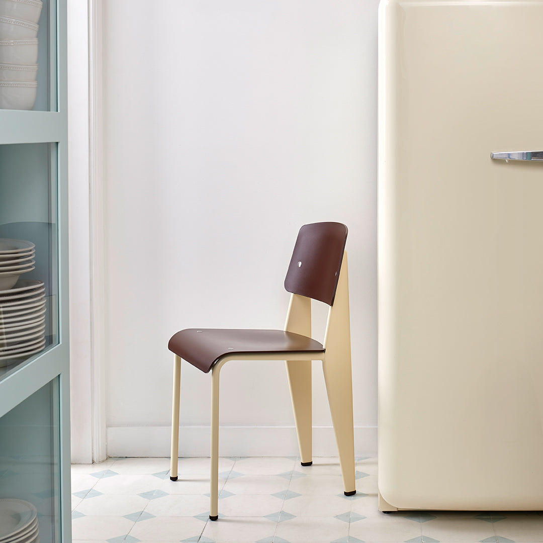 Brown and cream chair with a sleek design, set against a light-colored background and patterned floor.