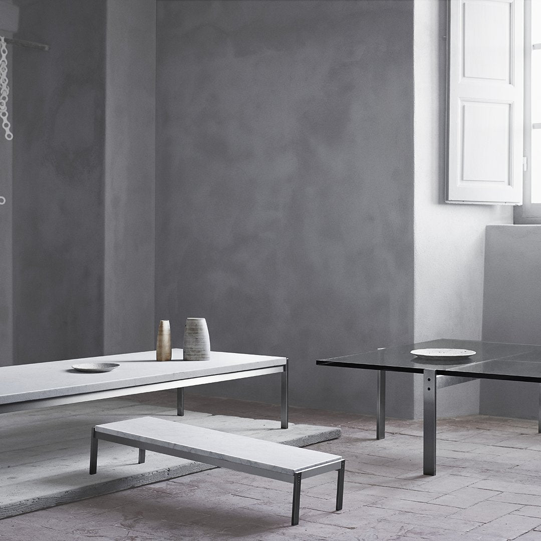 Modern gray and white coffee tables with sleek metal legs, featuring minimalist designs and subtle textures.