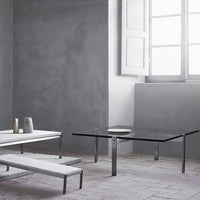 Minimalist gray and white furniture with sleek chrome accents, featuring a modern glass tabletop design.