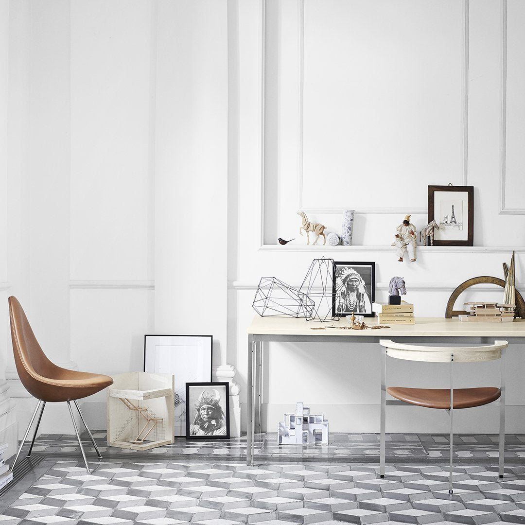 Scandi-style workspace featuring a monochrome geometric floor pattern and neutral decor accents with wooden elements.