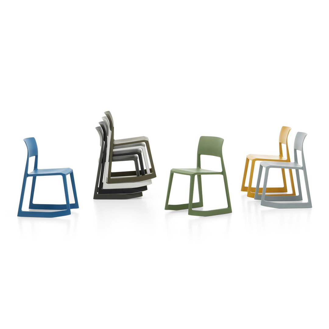 Colorful stackable chairs in blue, gray, green, and yellow, showcasing modern design and sleek patterns.