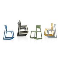 Colorful stackable chairs in blue, gray, green, and yellow, showcasing modern design and sleek patterns.