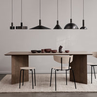 "Modern dining table with a walnut finish, black accents, and neutral tones in decor, featuring minimalist patterns."