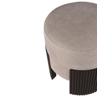 Round beige ottoman with textured surface and sleek dark brown ribbed legs. Modern and stylish accent furniture.