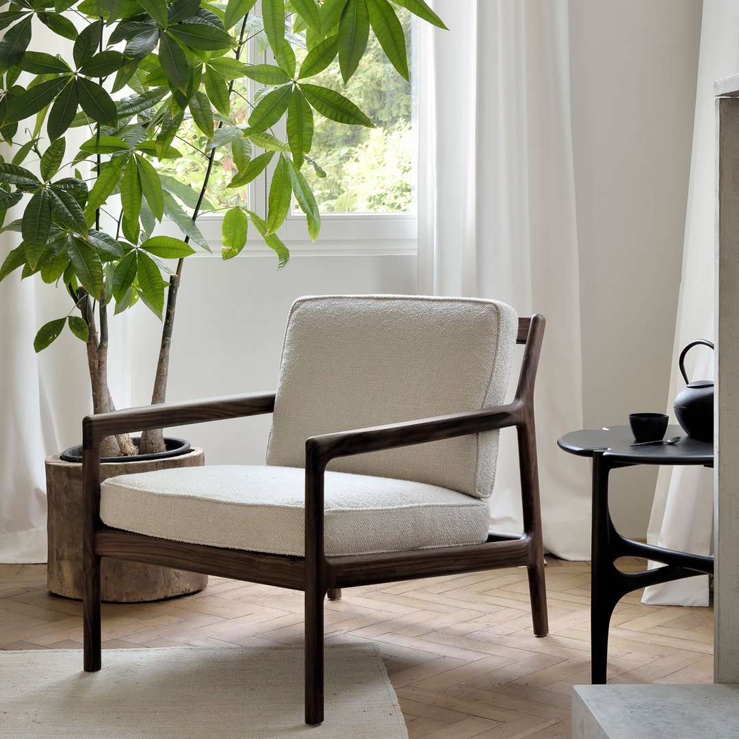 Neutral beige upholstery with a smooth texture, complemented by a dark wood frame and natural greenery.