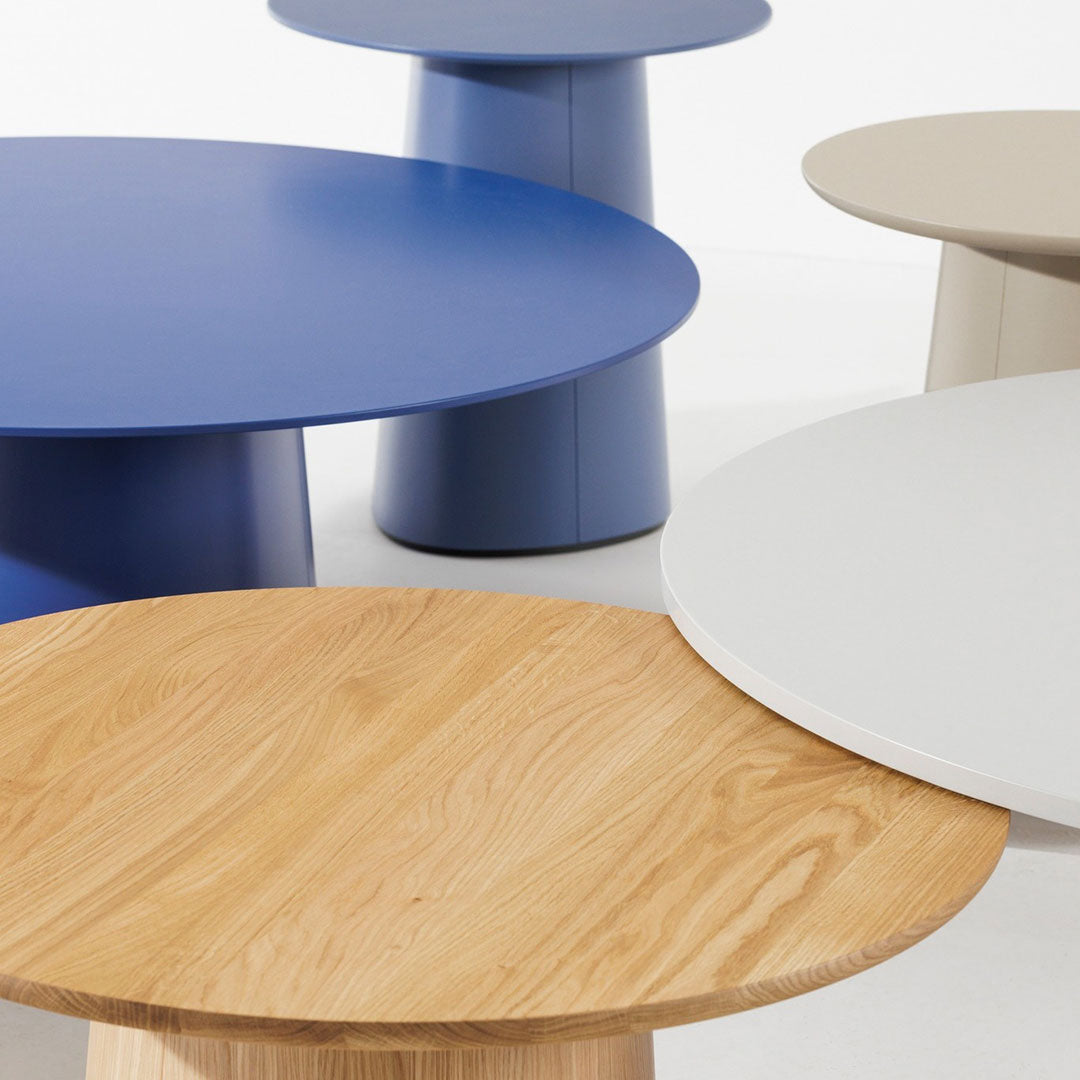 Colorful round coffee tables in blue, beige, white, and natural wood finishes with sleek, modern designs.