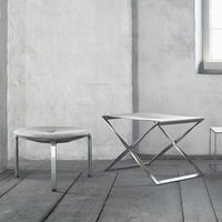 Modern gray furniture set featuring sleek metal accents and minimalist design on a textured floor.